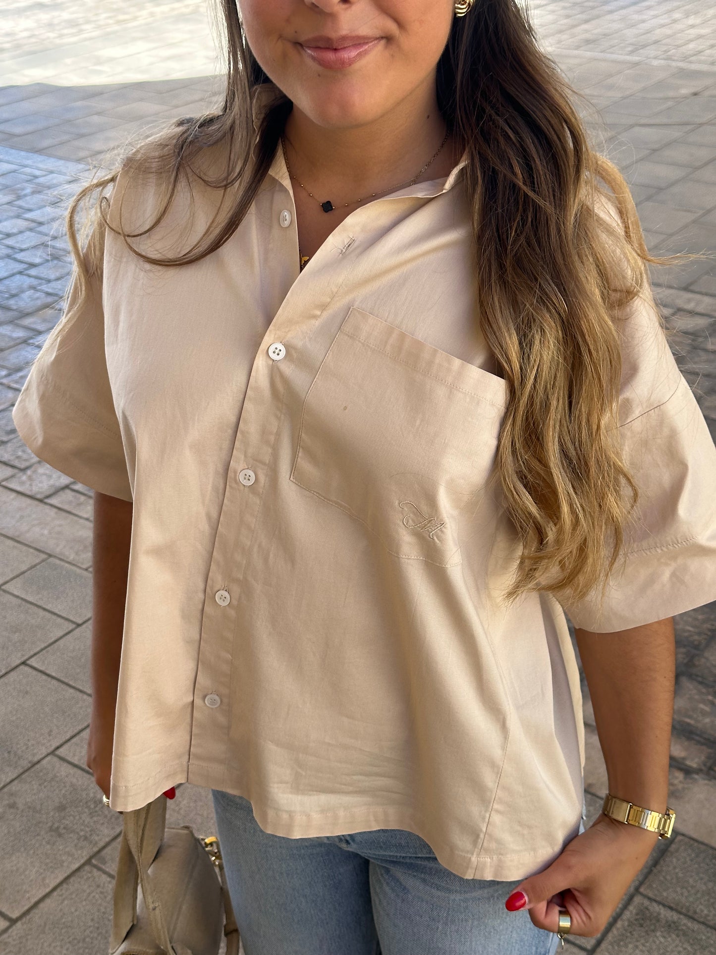 Femme portant une chemise dos ouvert beige. Collection printemps/été, mode éthique et féminine, fabriquée au Portugal avec des tissus dormants. 