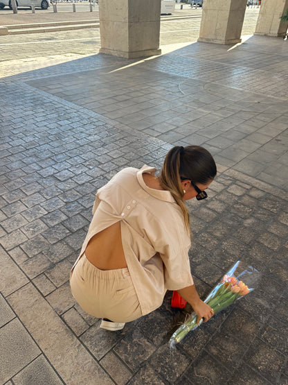 Femme portant une chemise dos ouvert beige. Collection printemps/été, mode éthique et féminine, fabriquée au Portugal avec des tissus dormants. 