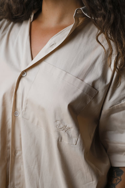 Femme portant une chemise dos ouvert beige. Collection printemps/été, mode éthique et féminine, fabriquée au Portugal avec des tissus dormants. 