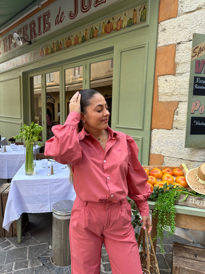 Femme portant une chemise oversize rose framboise avec des manches bouffantes. Collection printemps/été, mode éthique et féminine, fabriquée au Portugal avec des tissus dormants.