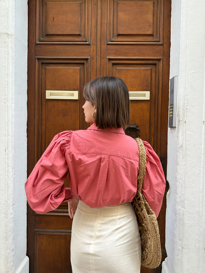 Femme portant une chemise oversize rose framboise avec des manches bouffantes. Collection printemps/été, mode éthique et féminine, fabriquée au Portugal avec des tissus dormants.