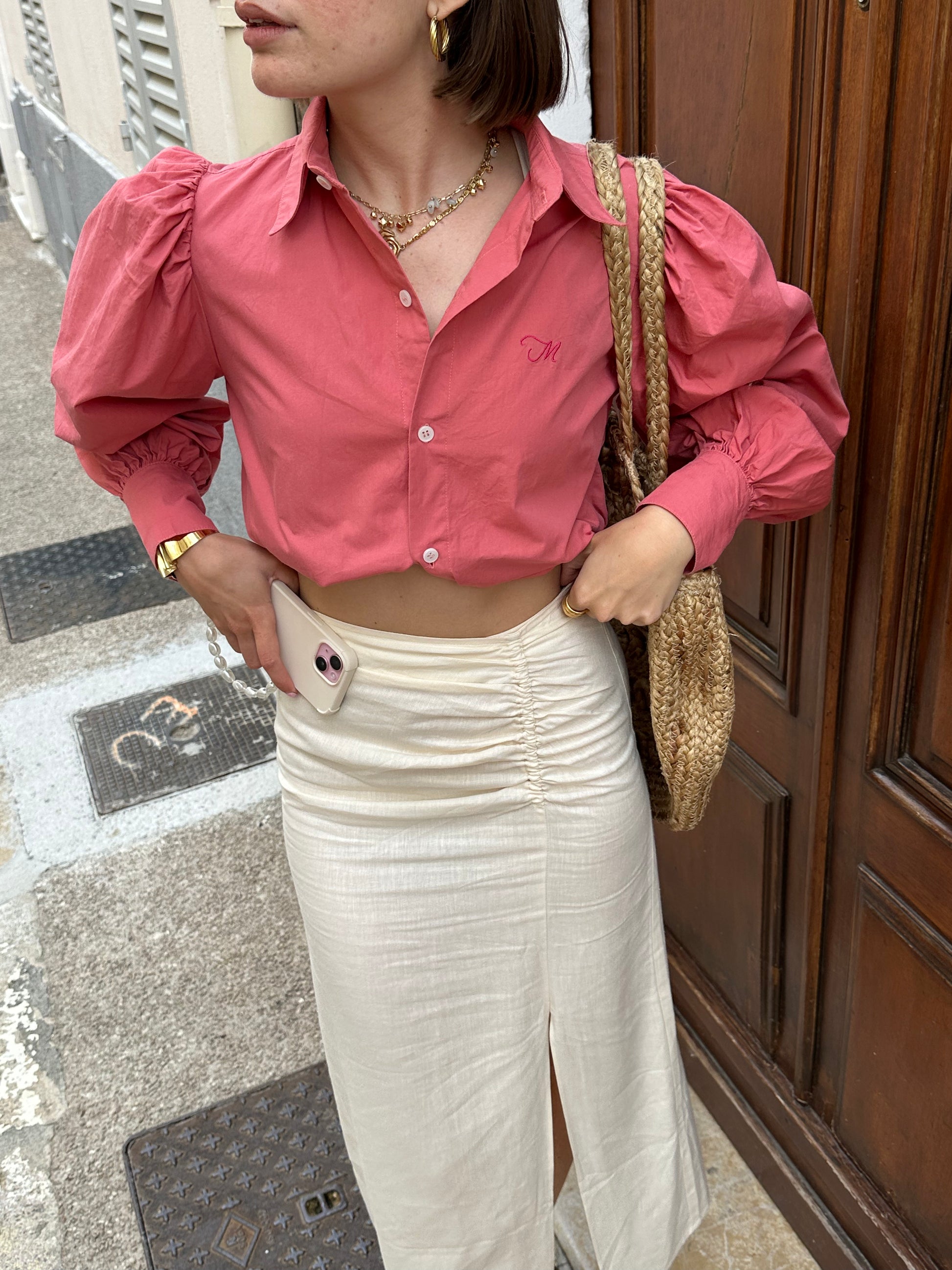 Femme portant une chemise oversize rose framboise avec des manches bouffantes. Collection printemps/été, mode éthique et féminine, fabriquée au Portugal avec des tissus dormants.