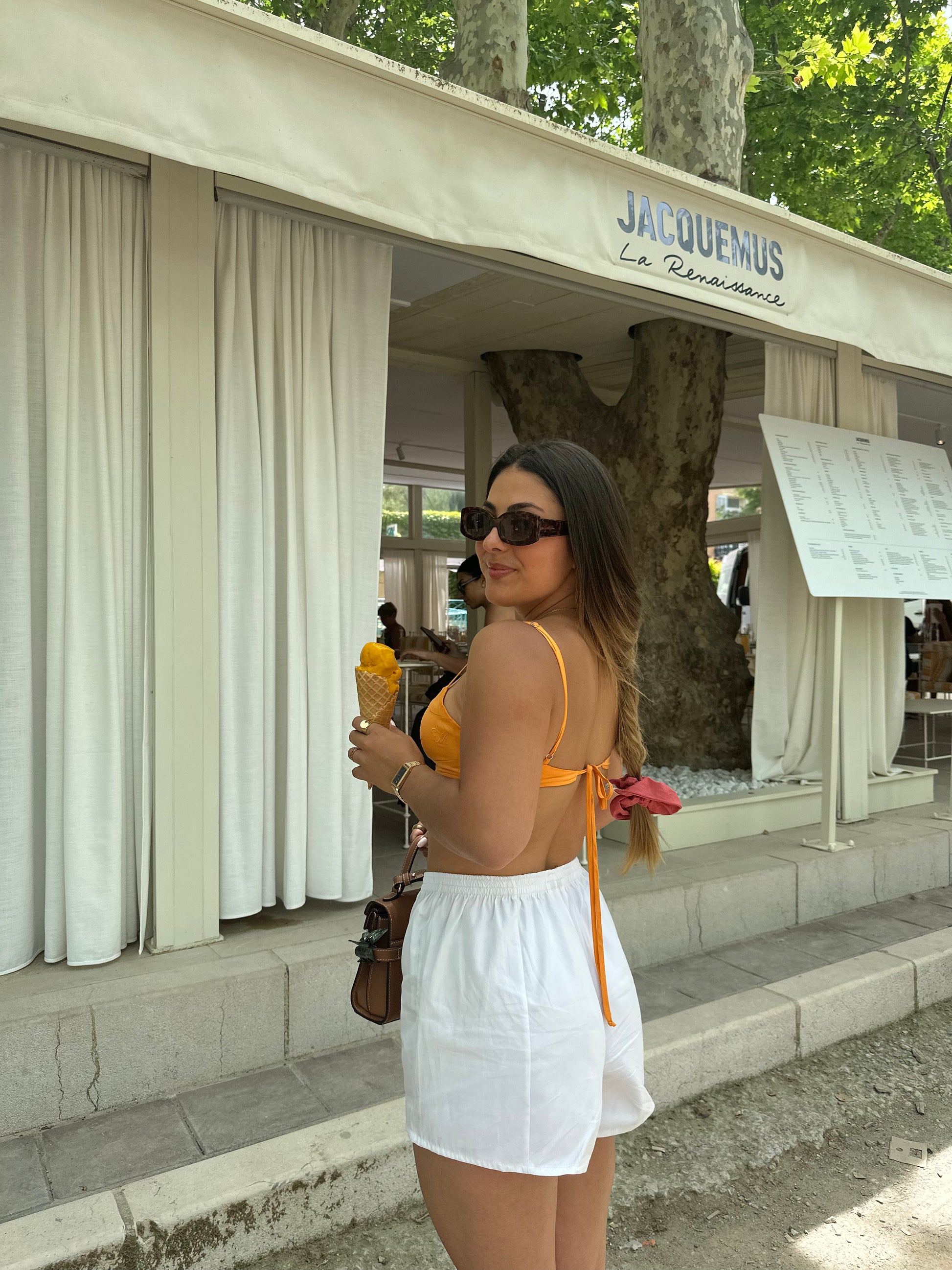 Femme portant un crop top orange. Collection printemps/été, mode éthique et féminine, fabriquée au Portugal avec des tissus dormants.