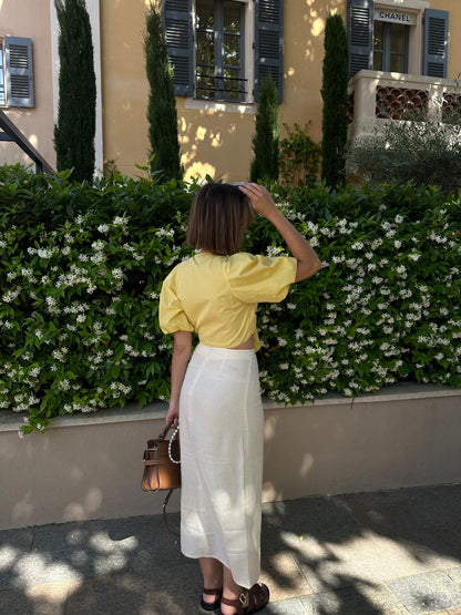 Femme portant une jupe longue jaune pâle avec une fente. Collection printemps/été, mode éthique et féminine, fabriquée au Portugal avec des tissus dormants.