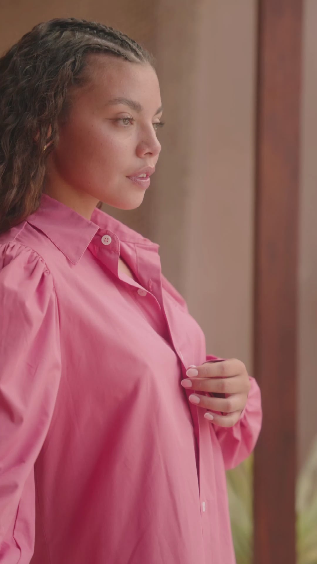 Femme portant une chemise oversize rose framboise avec des manches bouffantes. Collection printemps/été, mode éthique et féminine, fabriquée au Portugal avec des tissus dormants.