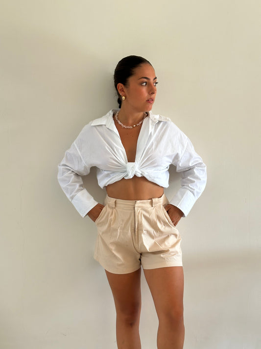 Femme portant un short tailleur beige. Collection printemps/été, mode éthique et féminine, fabriquée au Portugal avec des tissus dormants.